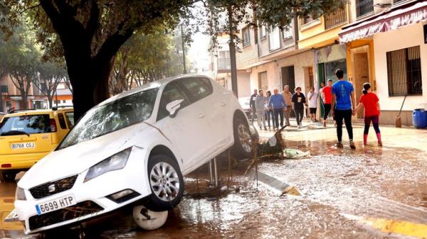 People walk along a mud-covered street after torrential rains caused flooding in La Alcudia.
Pic: Reuters